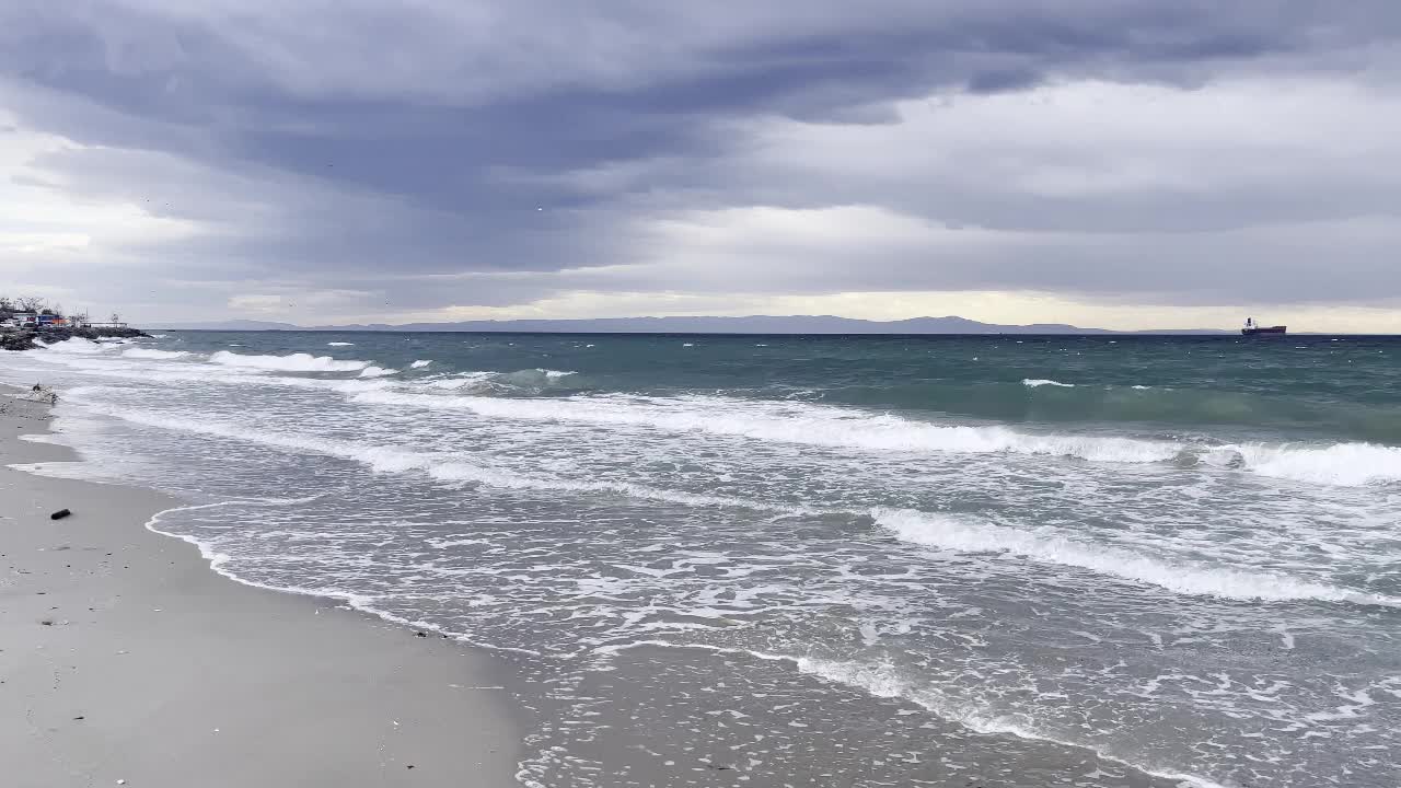 冬季海滩上的海浪和伊斯坦布尔马尔马拉海多云的天气。视频素材