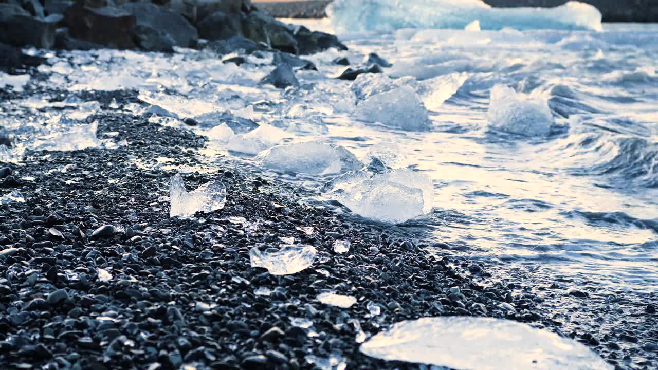 黑沙上的大块冰块，全球变暖气候变化概念，冰岛Jokulsarlon冰川泻湖的冰山视频素材