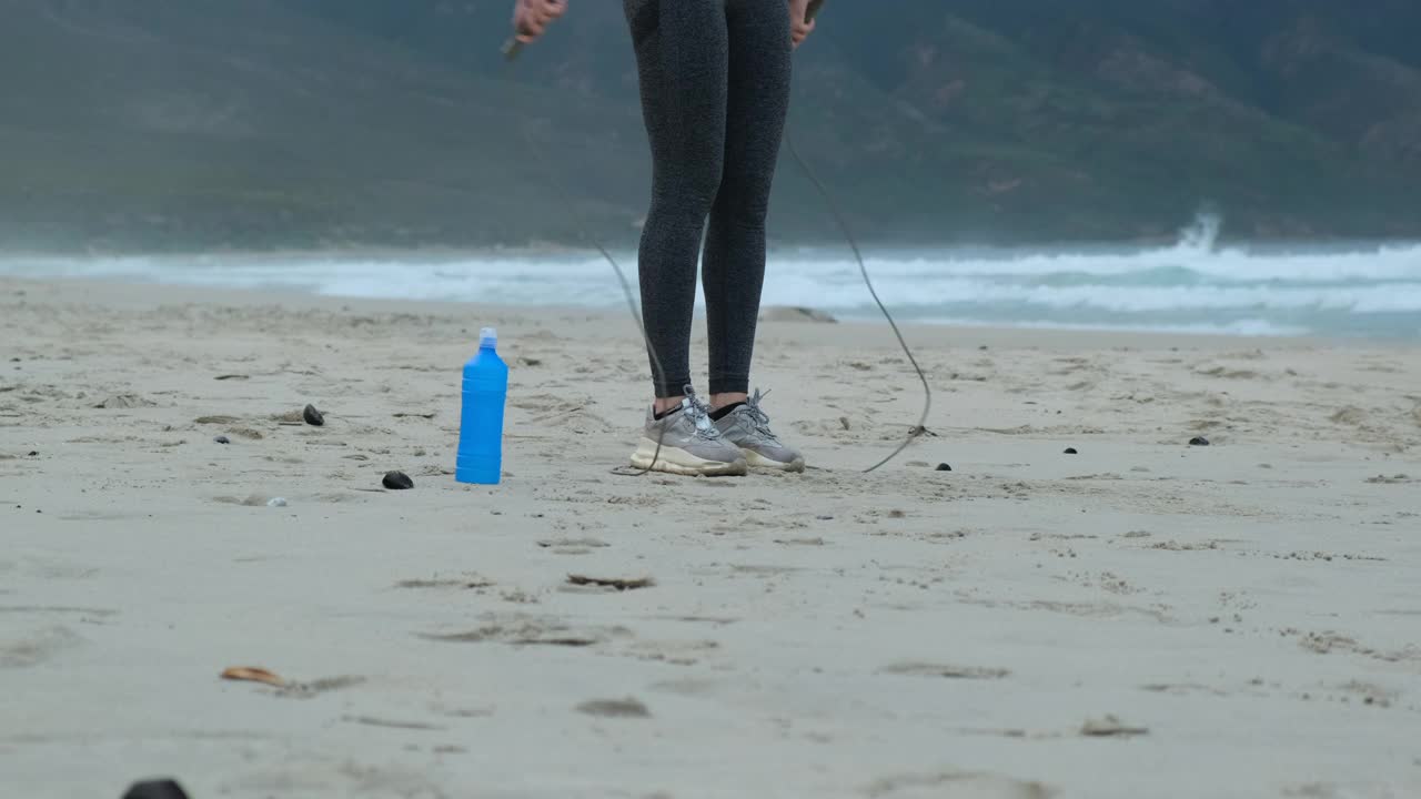 自信的年轻女子跳绳。在海边晨练视频素材