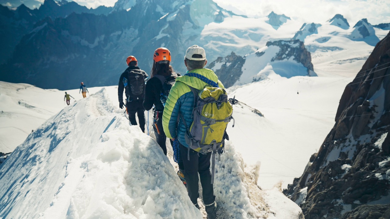 一组连续向上攀登的登山者。冬天的冒险。观点视频素材