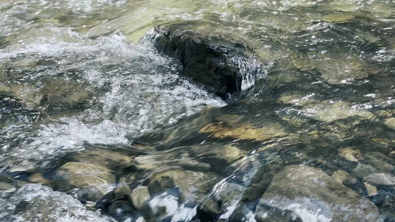 山上小溪上的石头景观。特写清澈的水流和岩石上的泡沫。视频素材