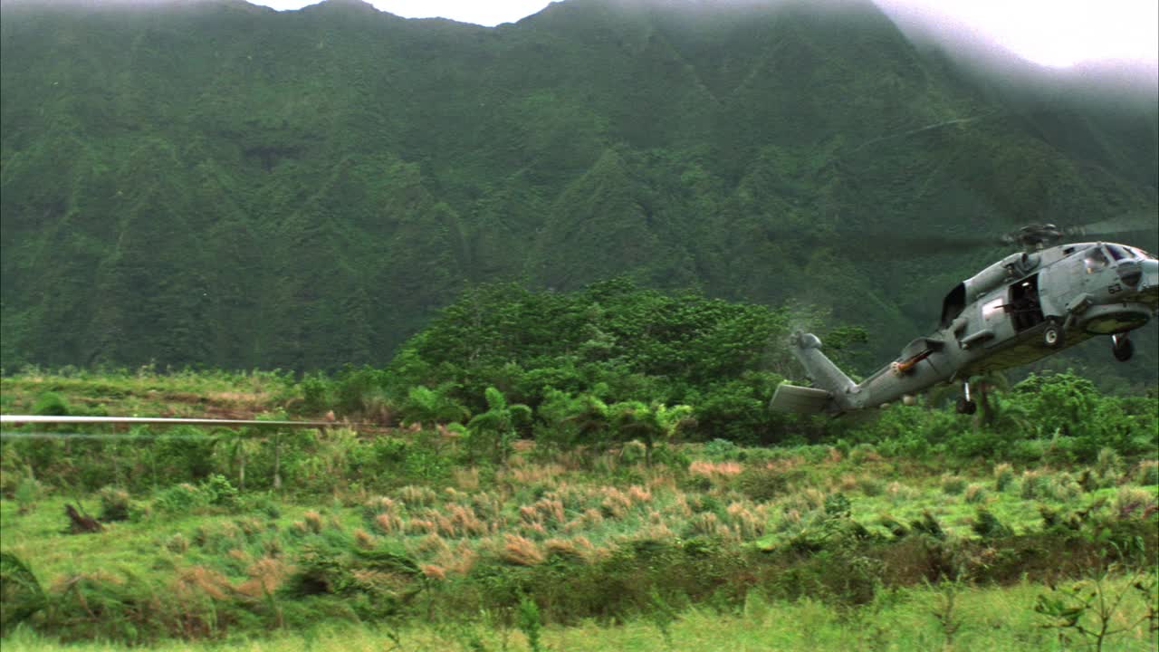 美国军用直升机sh-60b“海鹰”的广角镜头，在草地上空盘旋。热带雨林或热带丛林。山,KOOLAU范围。视频素材