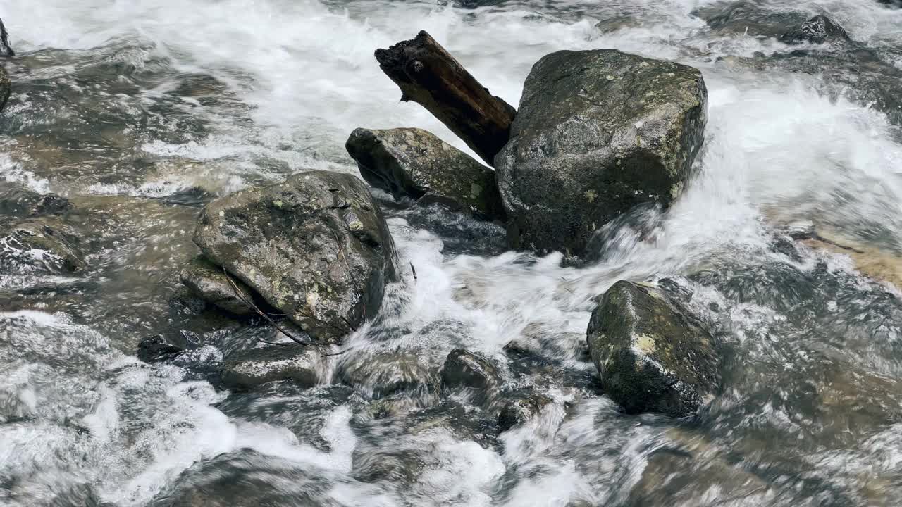 在冷水背景上的巨石。近景拍摄雨燕山河湿石。视频素材