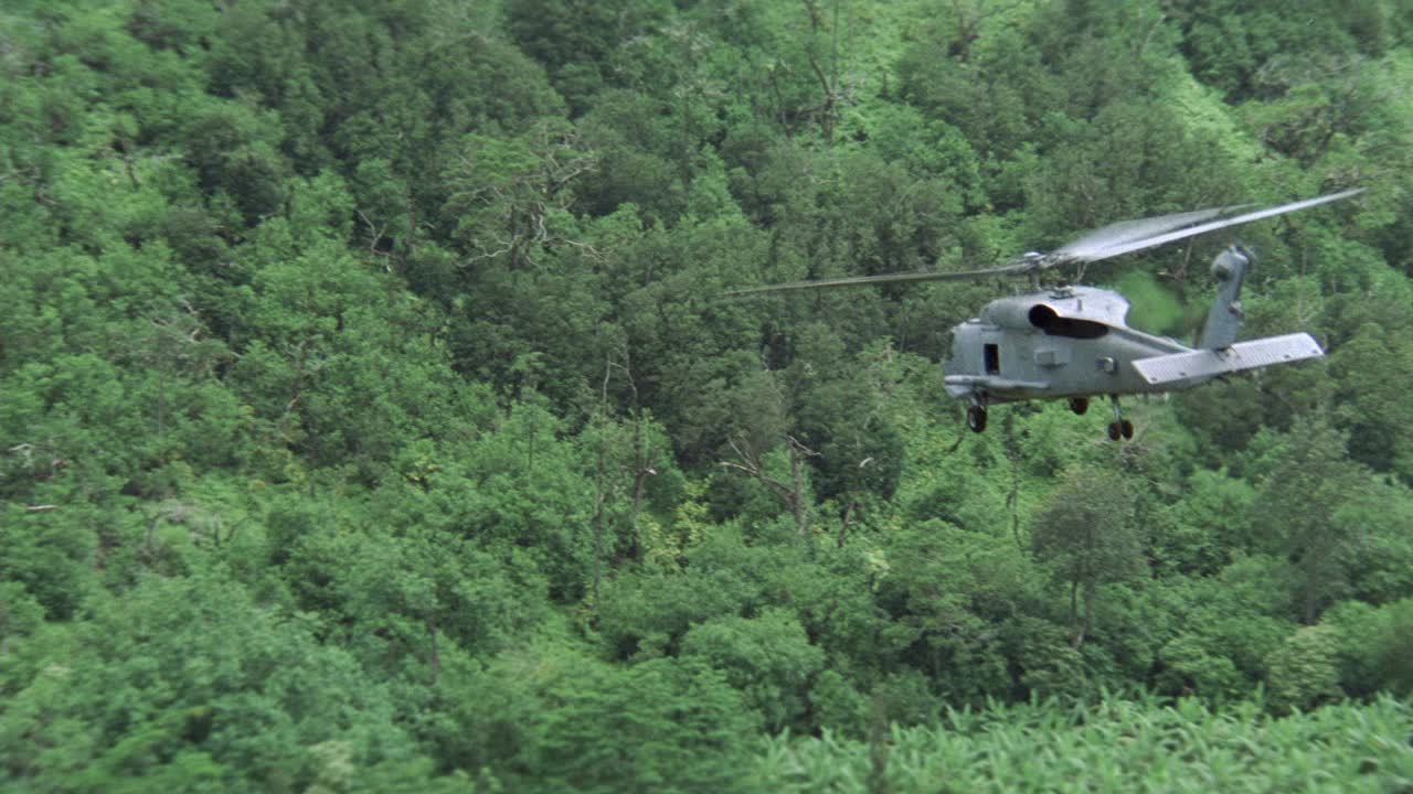 空中跟踪拍摄的两架sh-60b海鹰美国军用直升机飞越热带雨林或丛林。山麓。视频素材