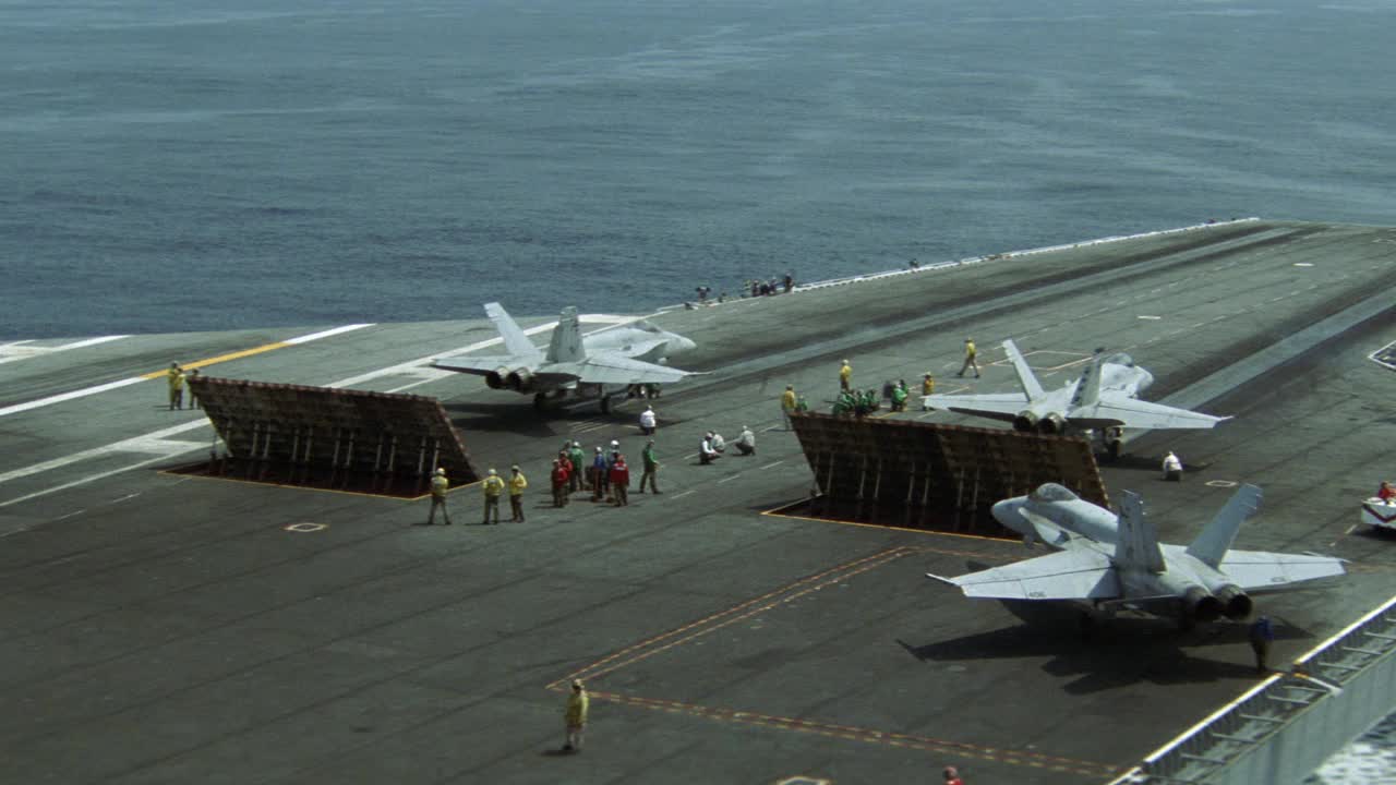 fa-18大黄蜂战斗机或军用飞机在跑道上准备起飞。喷射鼓风偏转板升起。飞行甲板船员。军队。哈利·s·杜鲁门号航空母舰(cvn-75)。BG的海洋。航空母舰。视频素材