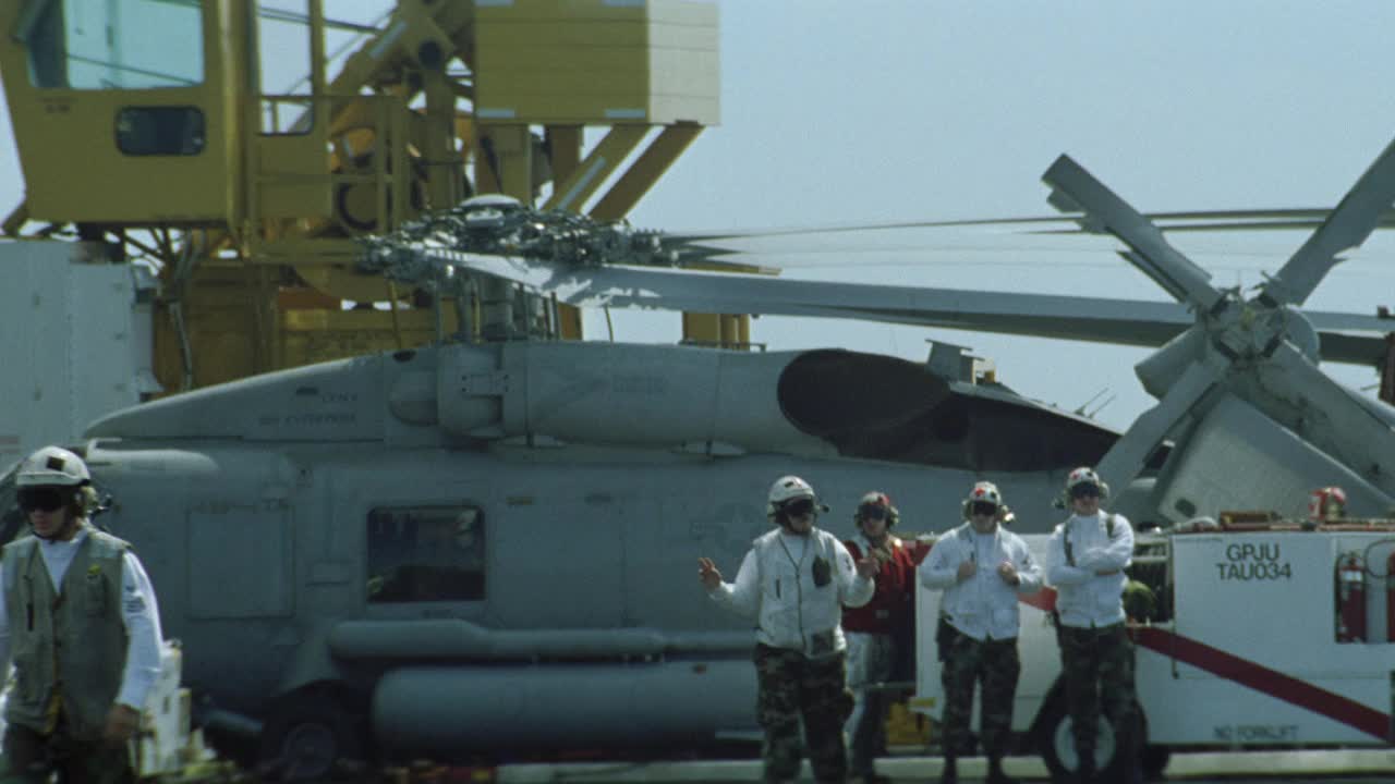 c-2a灰狗飞机在哈利s.杜鲁门号航空母舰的飞行甲板上滑行的中角度。飞行甲板机组人员协助飞机。Sh-60b海鹰直升机停在bg。起重机在BG。航空母舰。视频素材