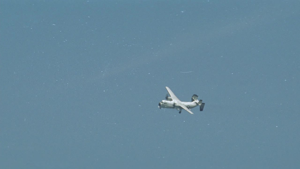 c-2a灰狗飞机广角降落在哈利s.杜鲁门号上。飞行甲板船员在甲板上。BG的海洋。蓝天白云。舰船雷达塔可见。航空母舰。视频素材