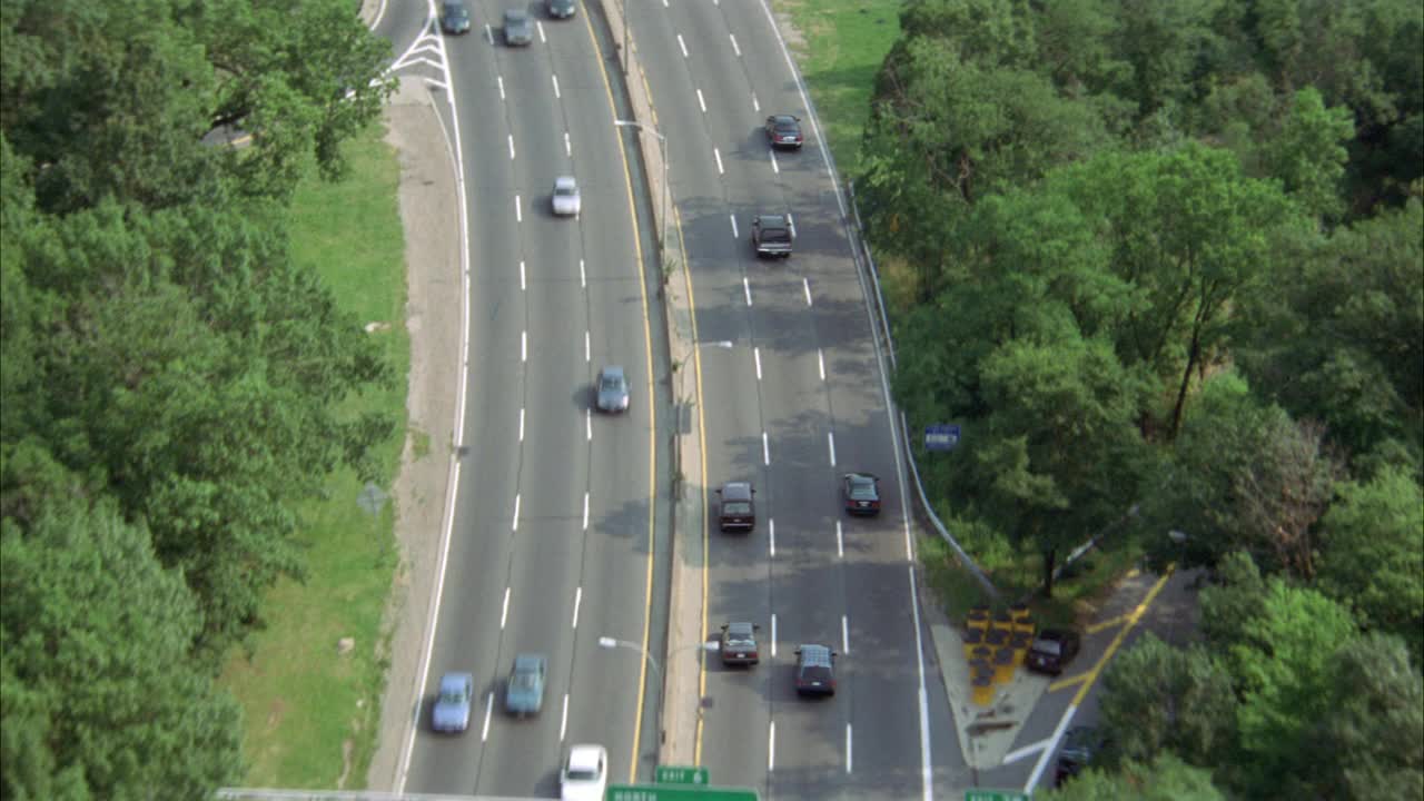 布朗克斯河公园道路的航拍图。汽车和越野车在树木环绕的公园道路上行驶。可以是freeway或highway。视频素材