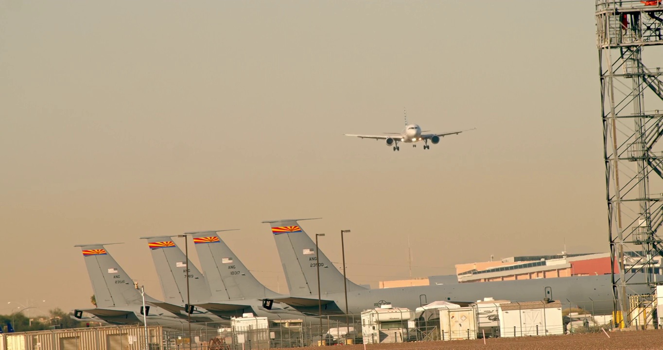 美国空军的飞机停在停机坪上，客机在头顶降落视频素材