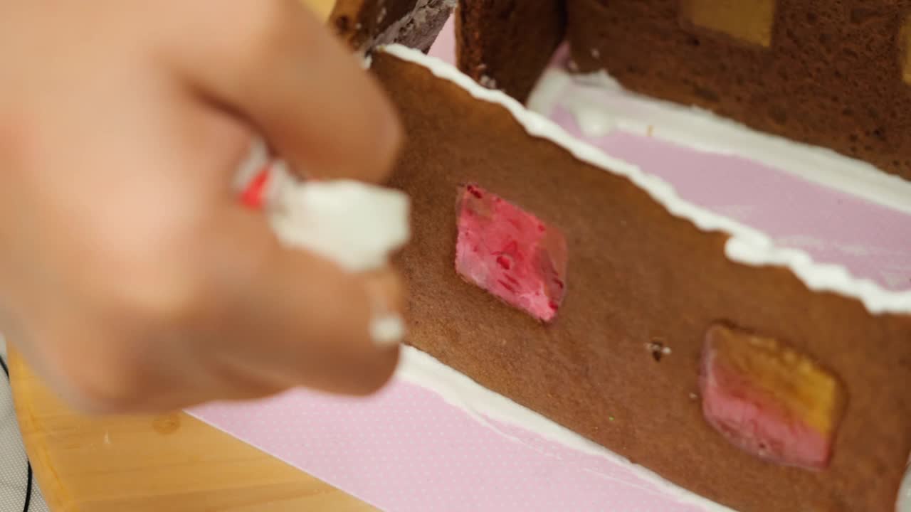 孩子的手做姜饼屋与妹妹在晚上的时间在家，庆祝圣诞节的生活理念。视频素材