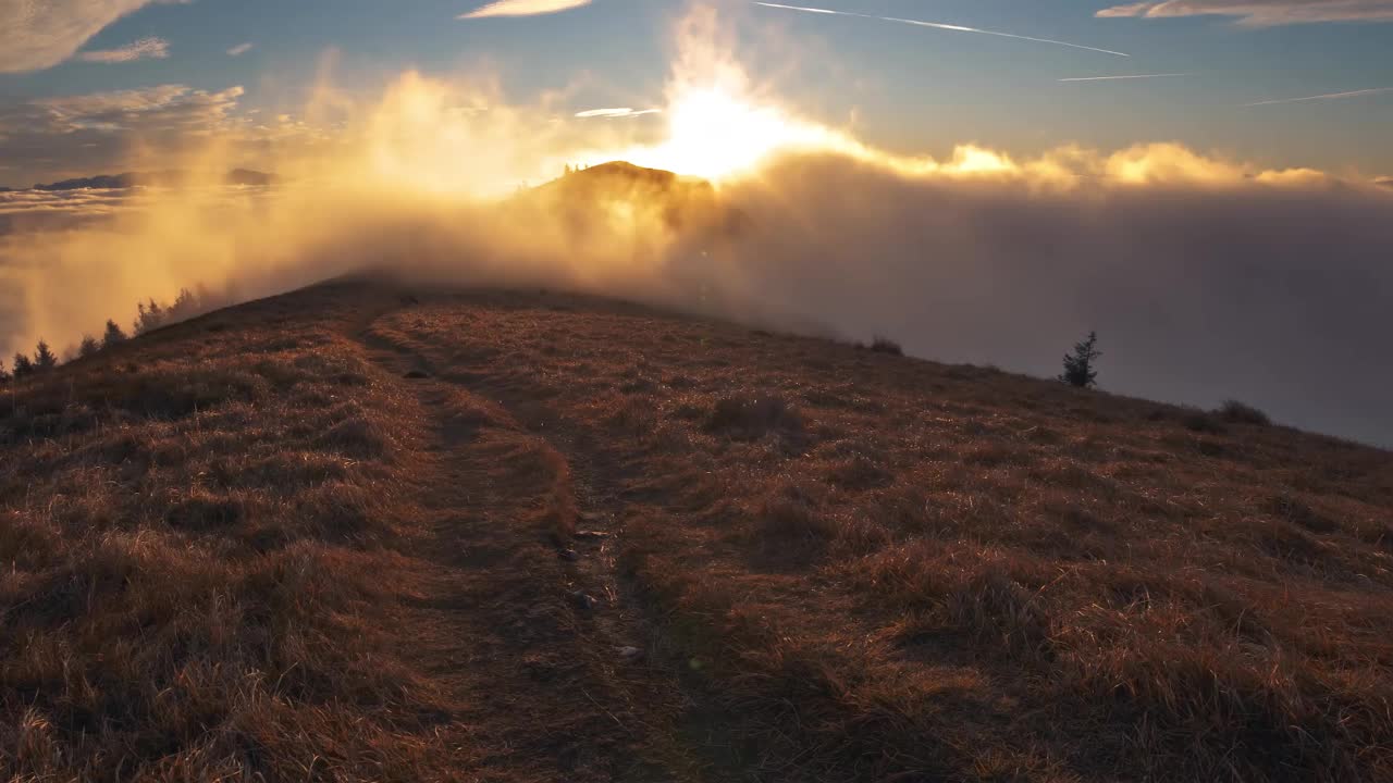 神奇的阳光明媚的早晨，大自然的日出与快速的云运动在秋天的山峰时间流逝视频素材