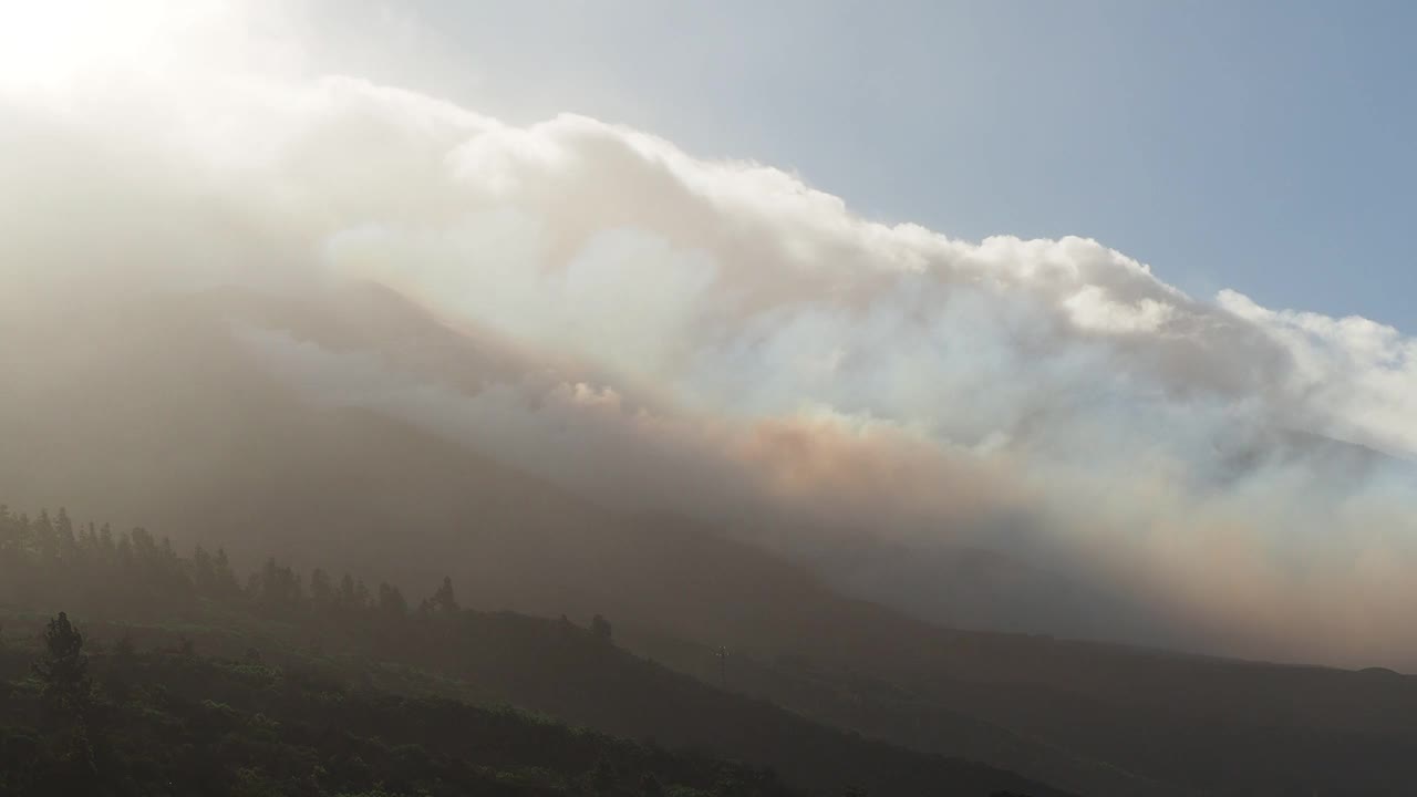 火山灰云和火山烟雾沿着火山喷发的斜坡下降。俯瞰康伯维哈火山，浓烟和熔岩柱从主锥中喷出。视频素材