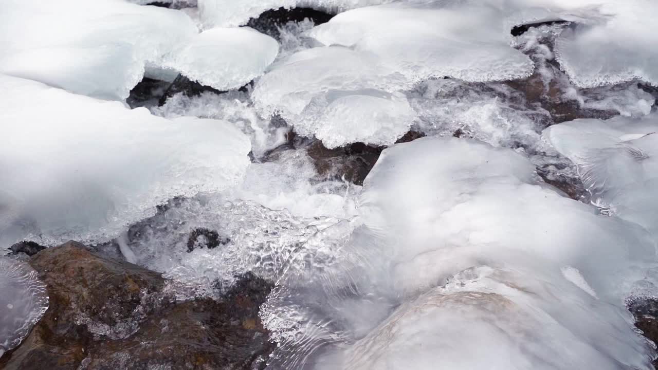 冬天湍急的山间河流的路线。冰冻的水和冰。缓慢的运动。视频素材