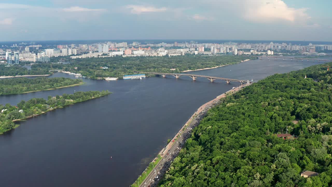 美丽的飞机从乌克兰首都基辅上空飞过。公园和树冠在绿叶中。许多房屋、桥梁和第聂伯河。视频素材