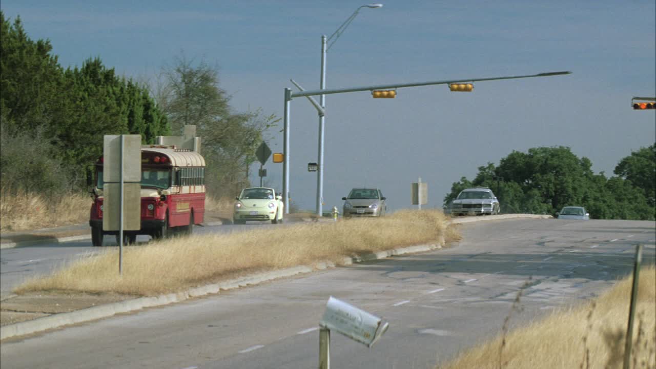 广角校车行驶在乡村或乡村道路。紧跟在busÊ后面的汽车可能在美国南部或中西部。红绿灯和损坏的邮箱。总线翻转。视频素材