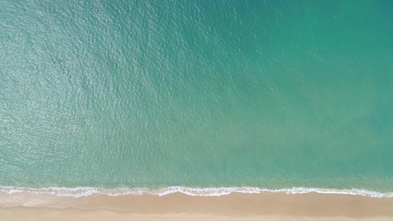 热带海与蓝绿色的海水和海浪撞击在沙滩上鸟瞰图海天堂岛从上到下的观点视频素材