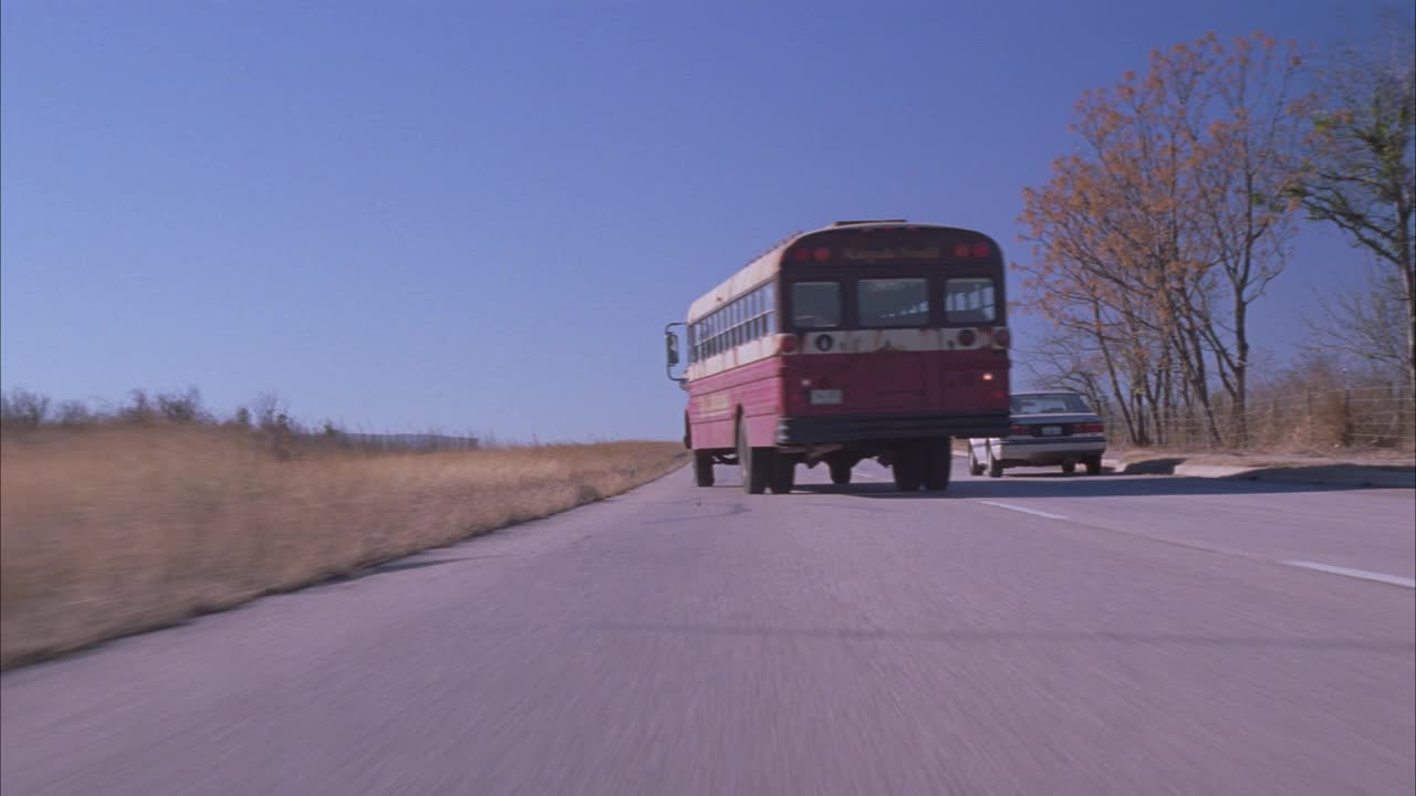 跟踪拍摄的校车后面行驶在乡村公路或分开的高速公路。大众新甲壳虫敞篷车追逐巴士。在车里和车外急转弯。Ê巴士尾部可能爆胎，巴士突然转向停车。墨西哥附近视频素材