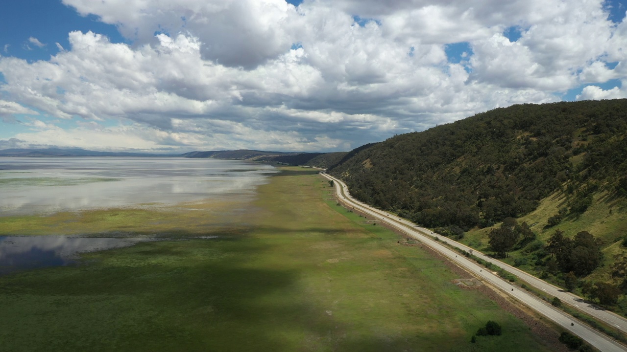 高速公路沿湖和山，汽车在澳运输视频素材