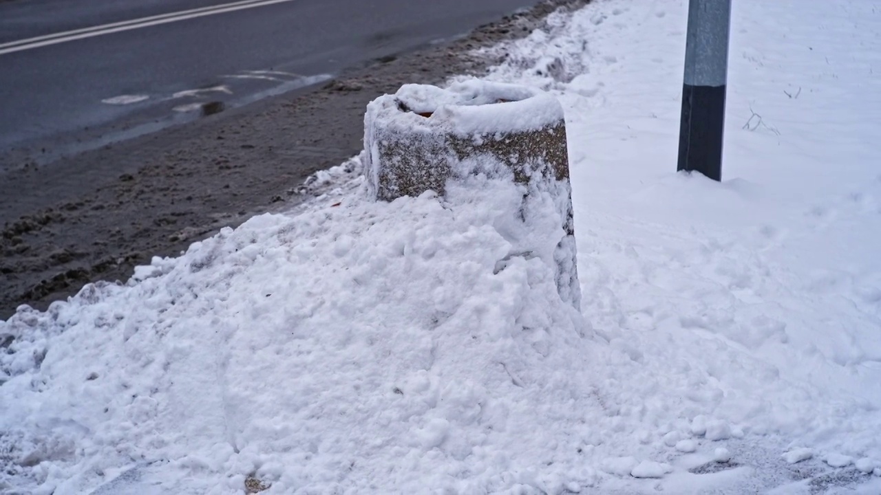 城市街道混凝土公共垃圾箱被大雪覆盖的垃圾箱在强烈的冬季降雪暴风雪视频素材