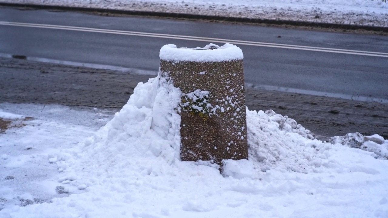 城市街道混凝土公共垃圾箱被大雪覆盖的垃圾箱在强烈的冬季降雪暴风雪视频素材