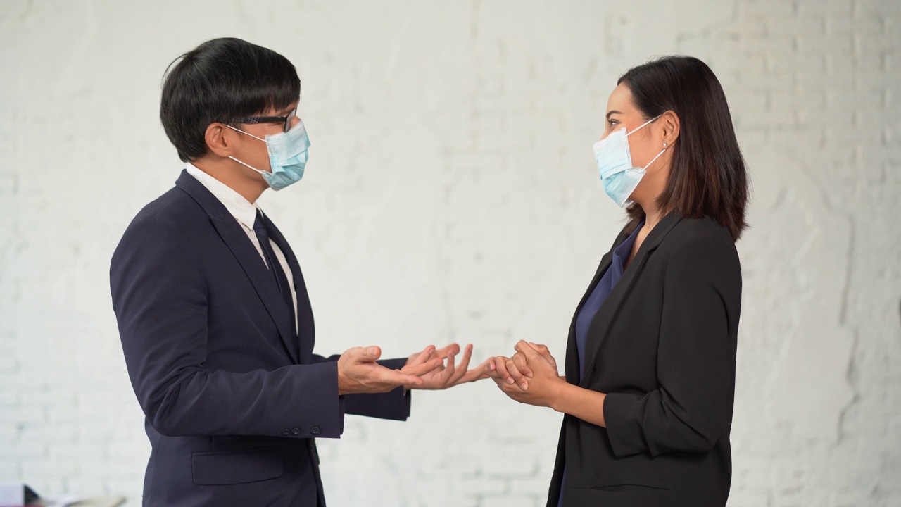 两名带着防护面罩的亚洲商人用肘撞来打招呼，而不是握手。在冠状病毒或Covid-19大流行期间，常见的问候用语视频素材