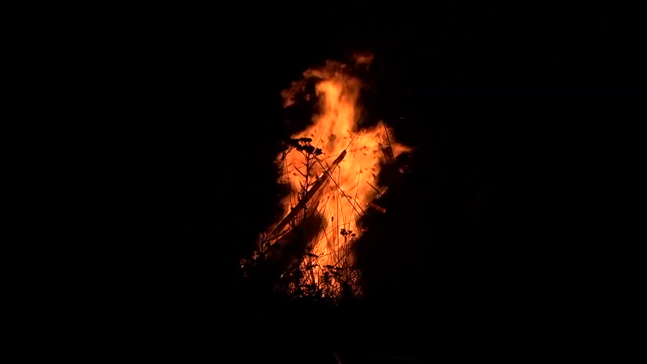 在黑夜的力量下，在草地中央用阀门燃烧着火焰视频素材