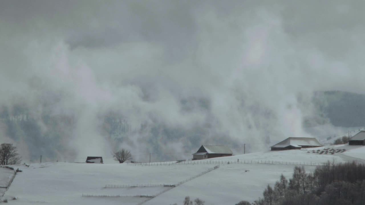 ’山坡从山的深处冉冉升起，覆盖在被白雪覆盖的房屋和马厩上视频素材