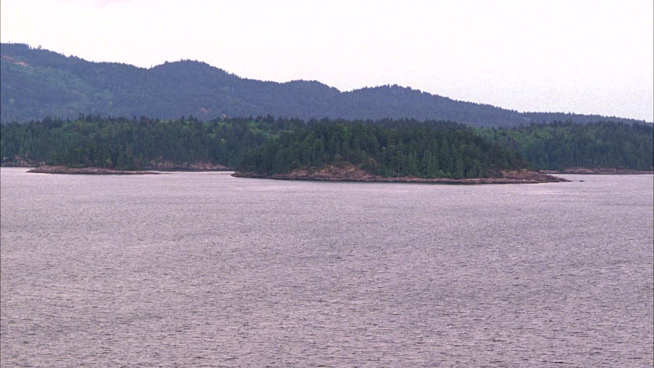 从左到右跨越海湾或湖泊。可见岛屿和山脉。可能是不列颠哥伦比亚省西温哥华的托菲诺。视频素材