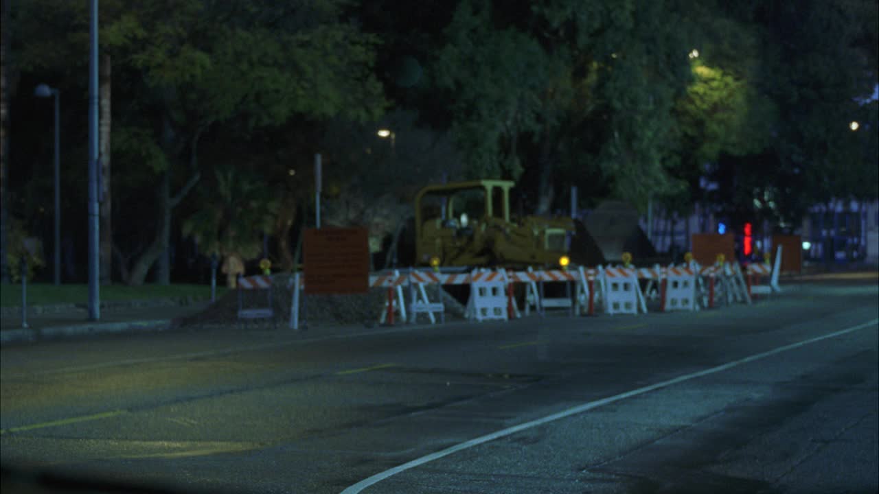 广角移动的视角从挡风玻璃的越野车，货车，或汽车撞击到建筑工地。推土机和交通障碍。闪烁的灯光。树木在BG。视频素材