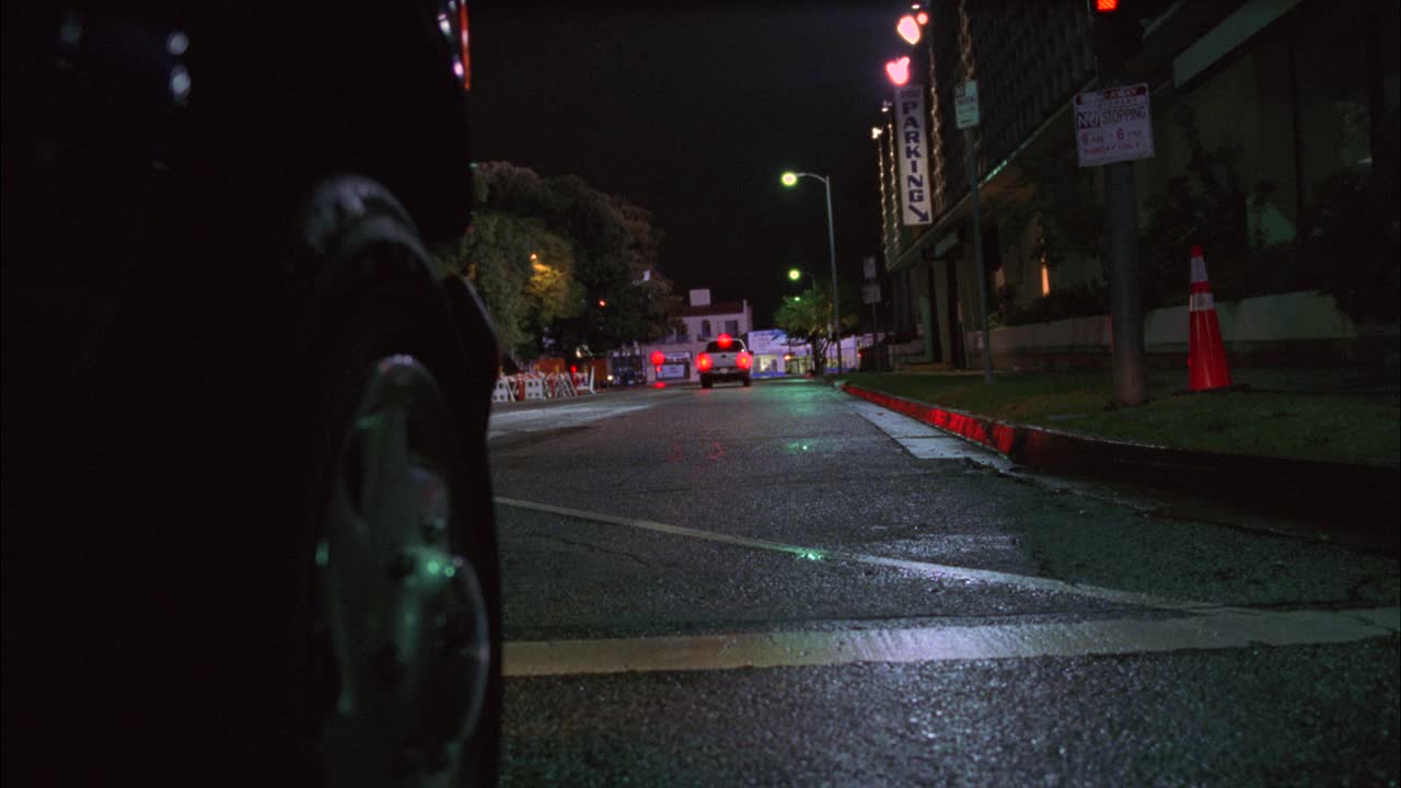 在被雨水冲刷的城市街道上，货车或越野车的轮胎的特写角度。货车突然转向，差点撞到闪着灯的停车护栏上。汽车特技表演。轮毂。可以是建筑区域。视频素材