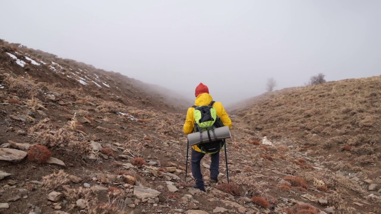 男子登山者站在山顶的山腰上视频素材