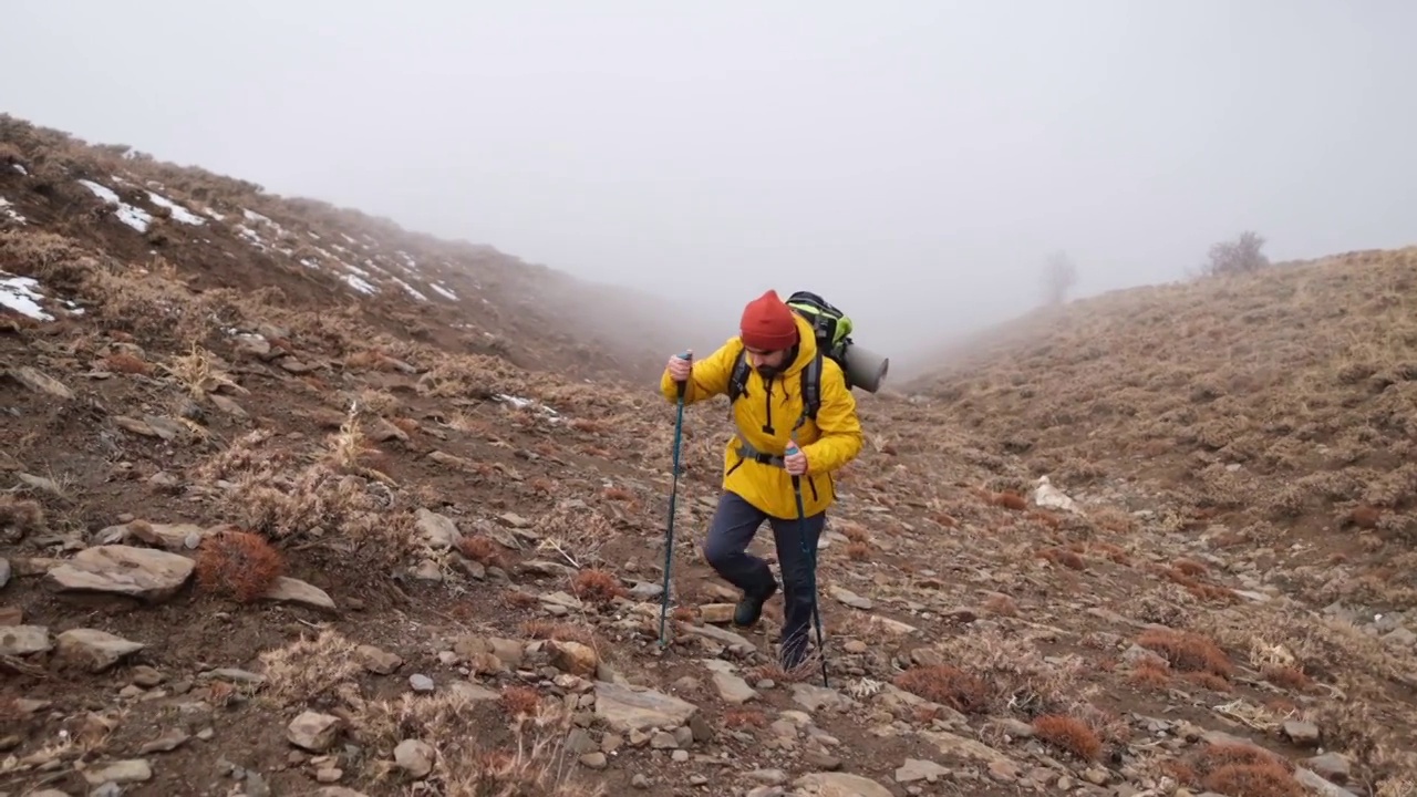 男子登山者站在山顶的山腰上视频素材