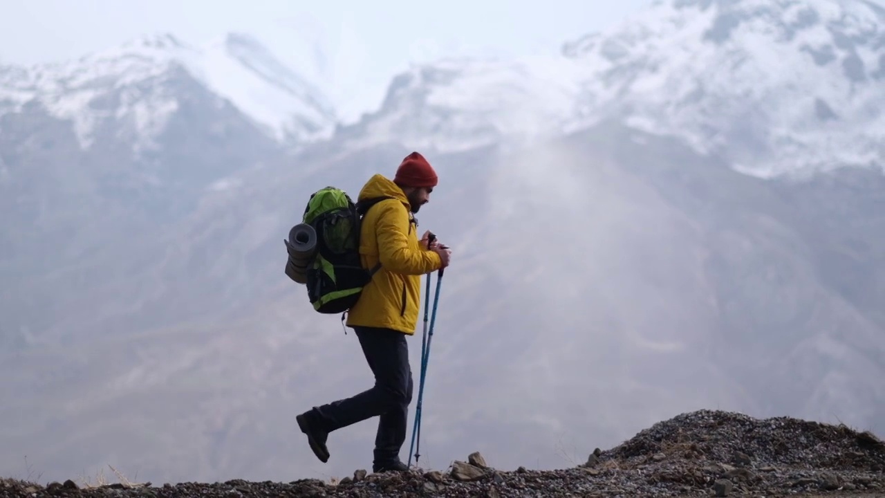 男子登山者站在山顶的山腰上视频素材