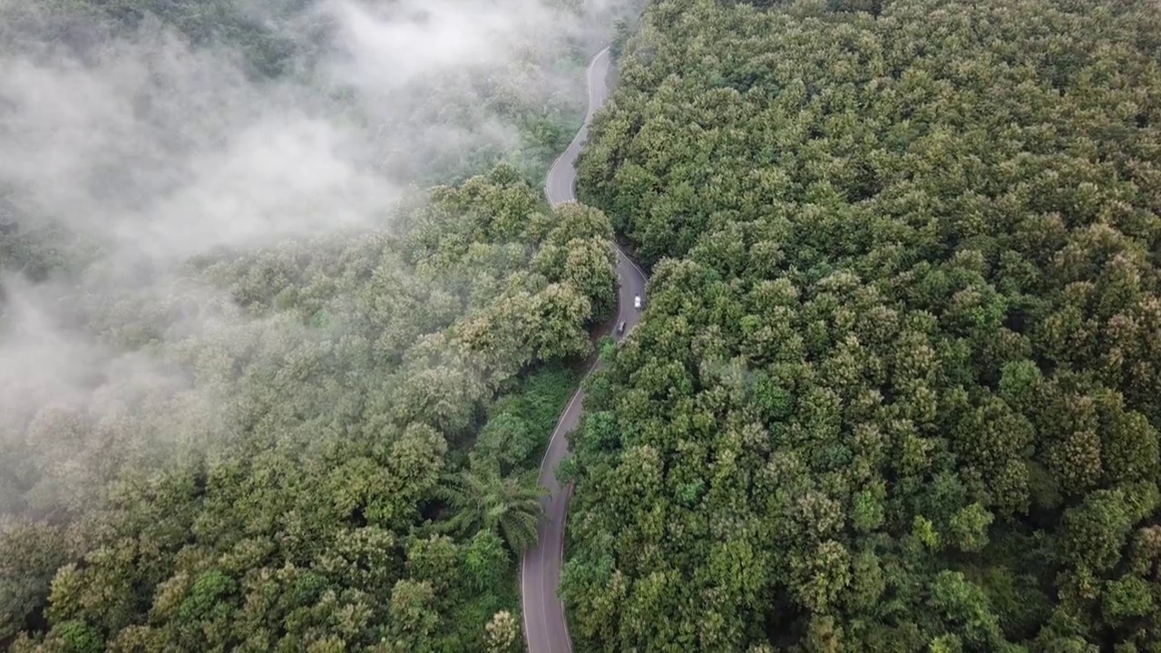 鸟瞰图，汽车行驶在穿越泰国农村山区的道路上。视频素材