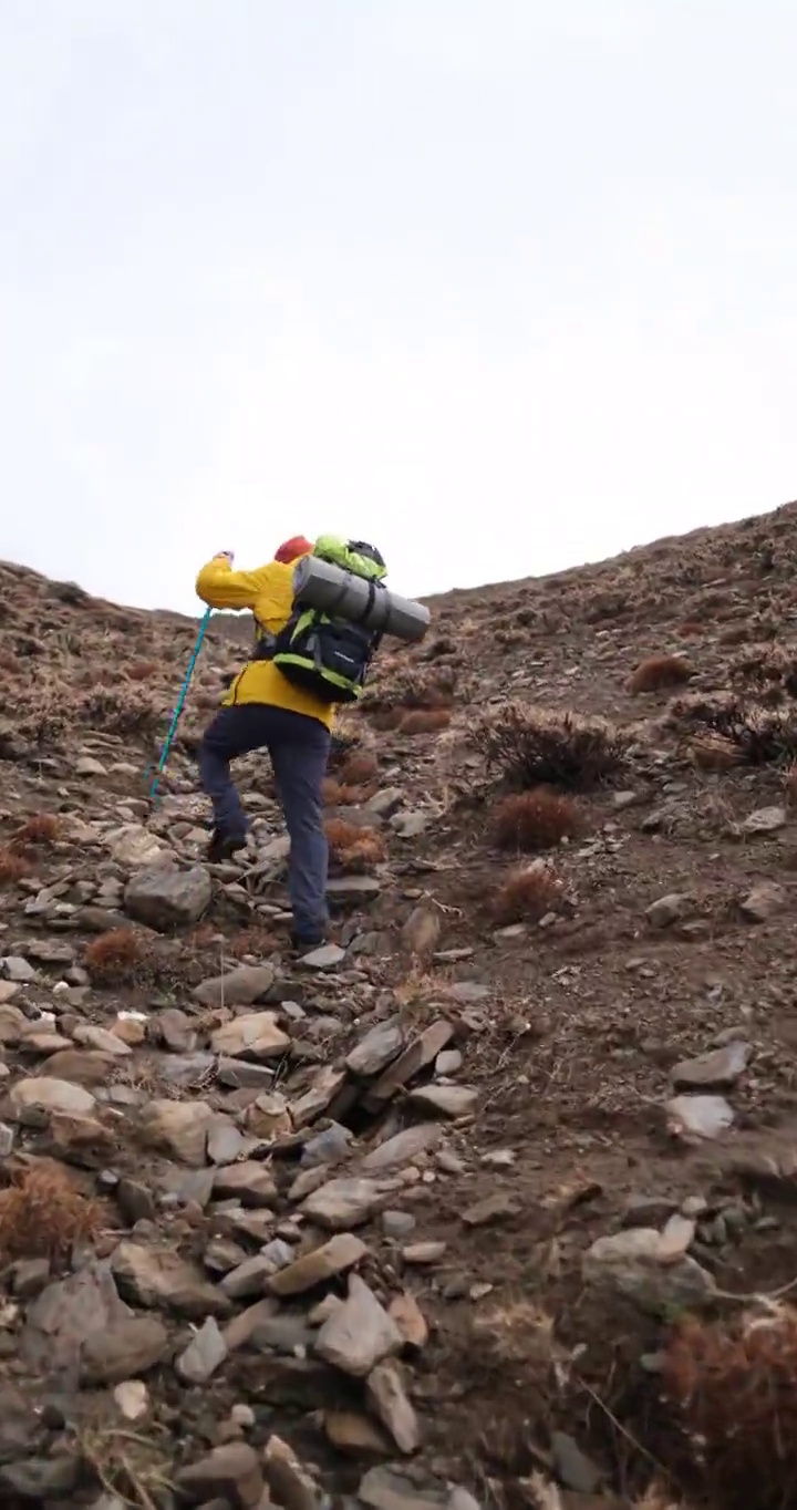 男子登山者站在山顶的山腰上视频素材