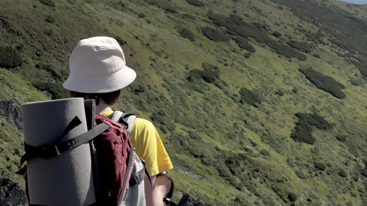 女游客走在山顶上。徒步旅行的人享受生活，风景秀丽，自然风光。暑假探险旅行。背包客徒步旅行高山夏季徒步旅行。视频素材