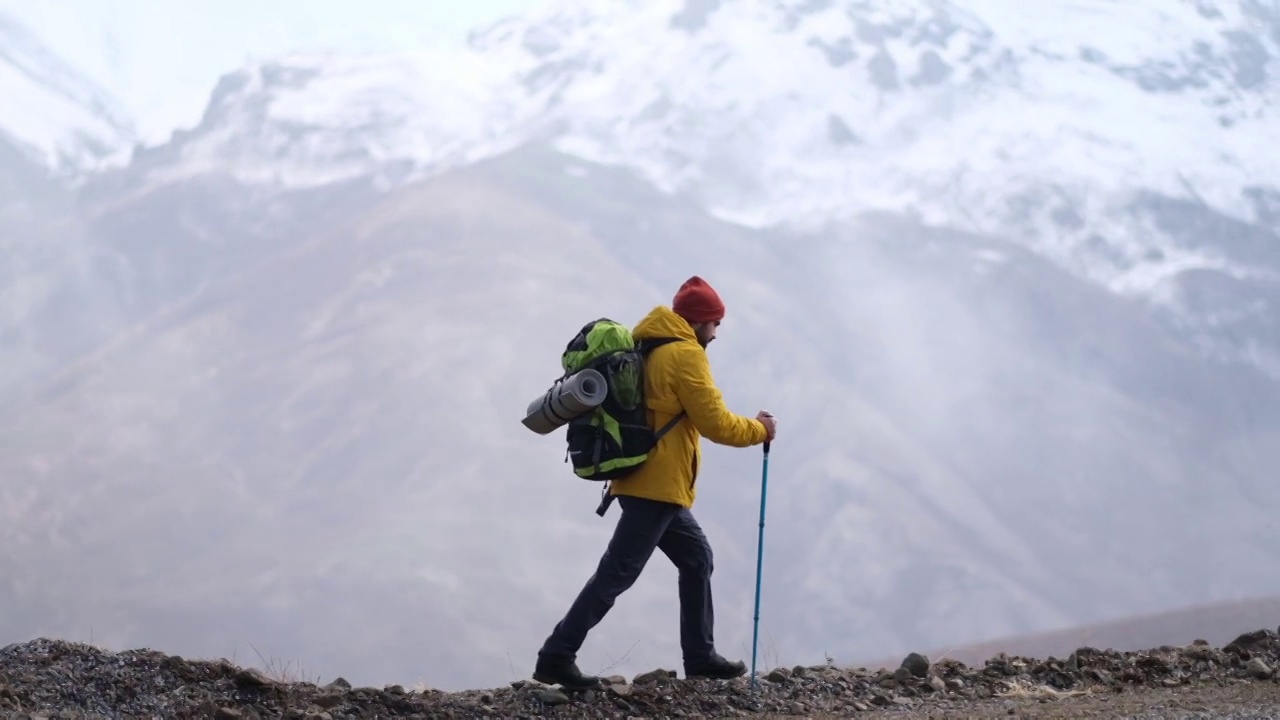 男子登山者站在山顶的山腰上视频素材