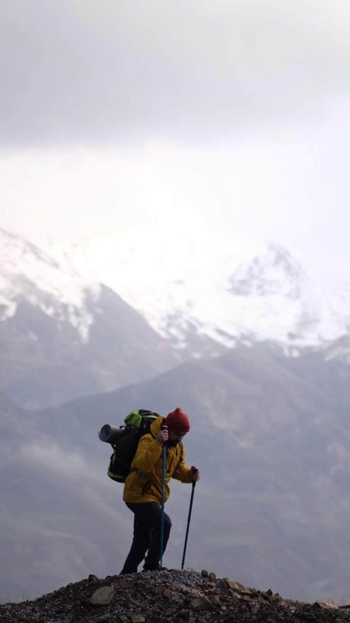 男子登山者站在山顶的山腰上视频素材