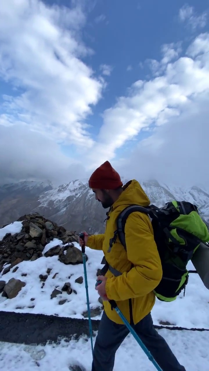 男子登山者站在山顶的山腰上视频素材