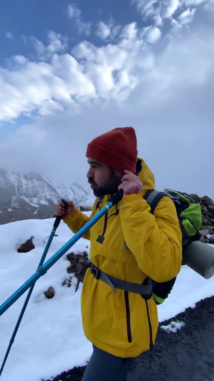 男子登山者站在山顶的山腰上视频素材