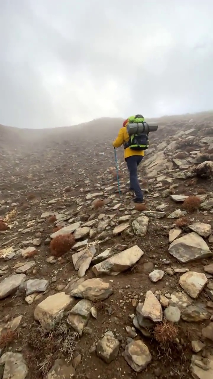 男子登山者站在山顶的山腰上视频素材