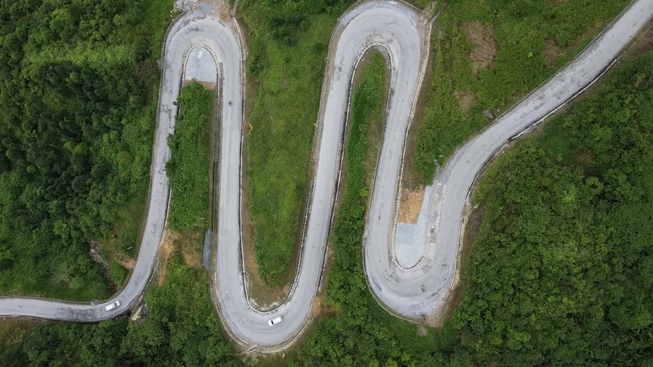 鸟瞰穿越森林的山路，从高山口出发的蜿蜒山路。山路上弯弯曲曲的小路视频素材