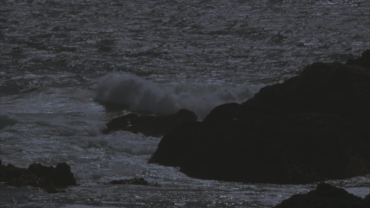 近角度海浪冲击岩石沿崎岖的海岸线。海洋。60 FPS。视频素材