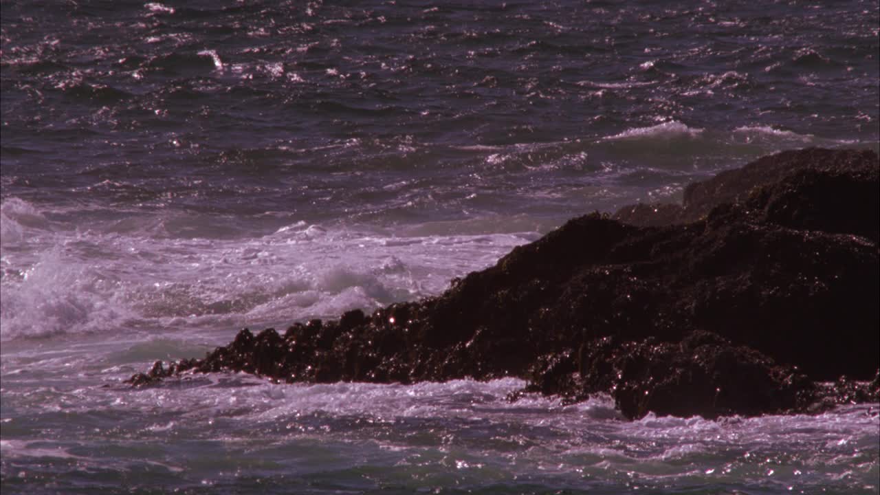 近角崎岖的海岸线。海浪拍打着岩石。60 FPS。视频素材