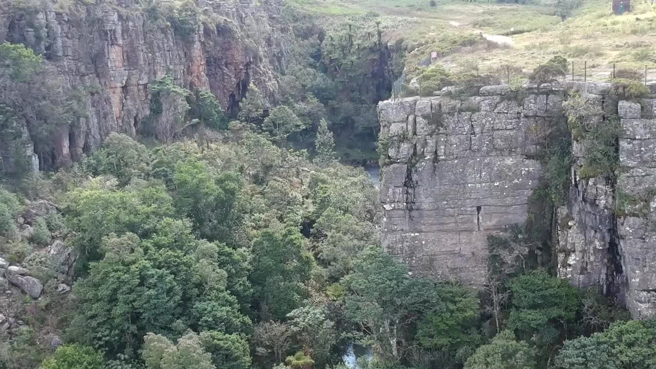 陡峭的岩石面和郁郁葱葱的绿色植被与瀑布视频素材