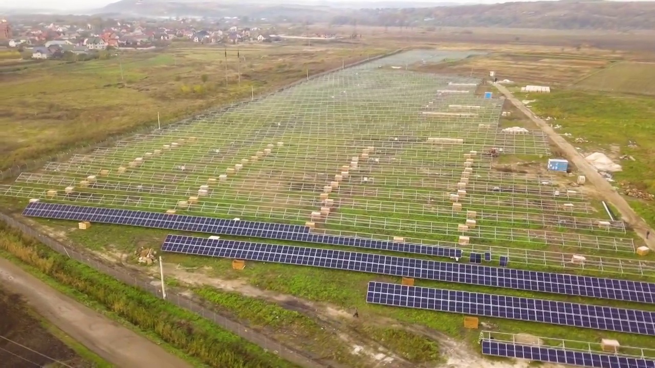 在绿地上建造太阳能发电厂的鸟瞰图。生产清洁生态能源的电板装配视频素材