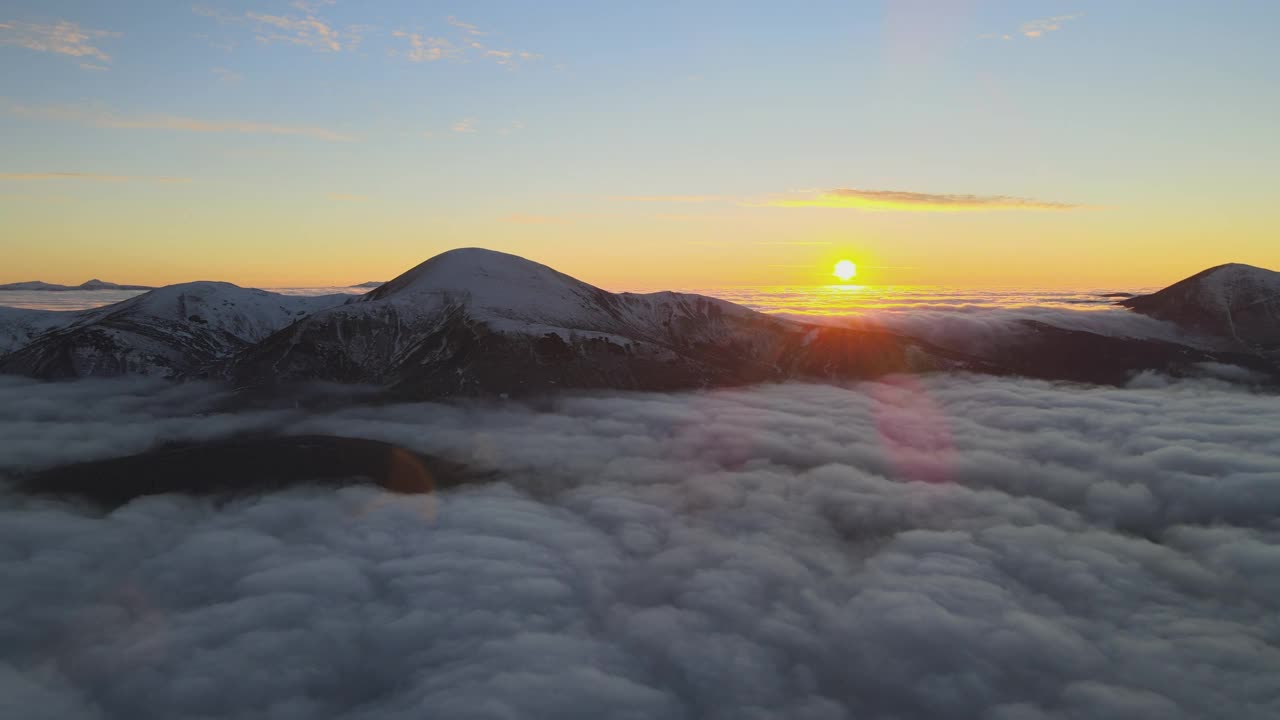 从空中俯瞰，在白色浓雾中充满活力的日出，地平线上是遥远的喀尔巴阡山脉的深色山峰视频素材