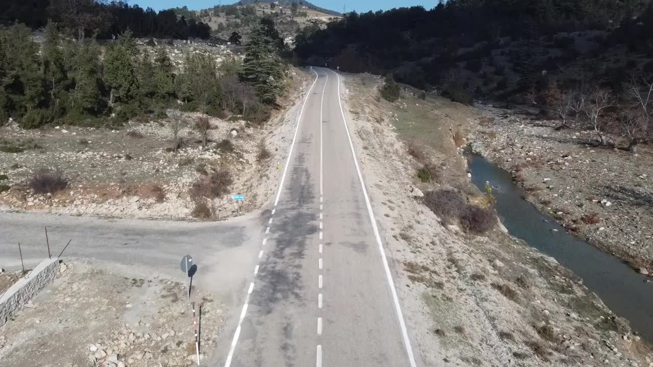 在森林的柏油路上用无人机飞行。视频素材