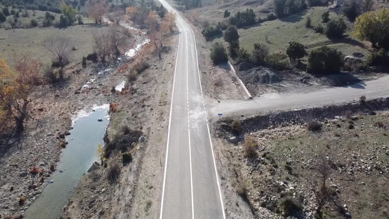 在森林的柏油路上用无人机飞行。视频素材