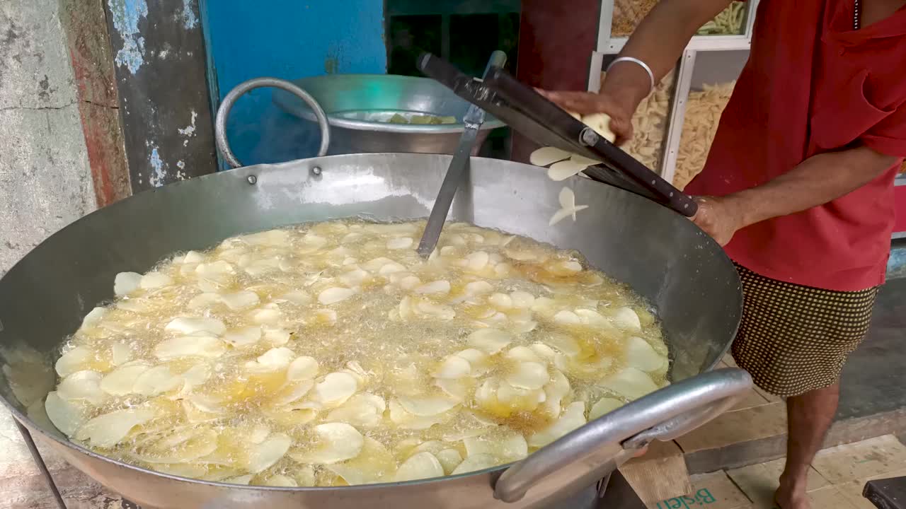 在印度的一个小街头食品中心，用传统的方法制作薯片的过程，没有使用现代机器。视频素材